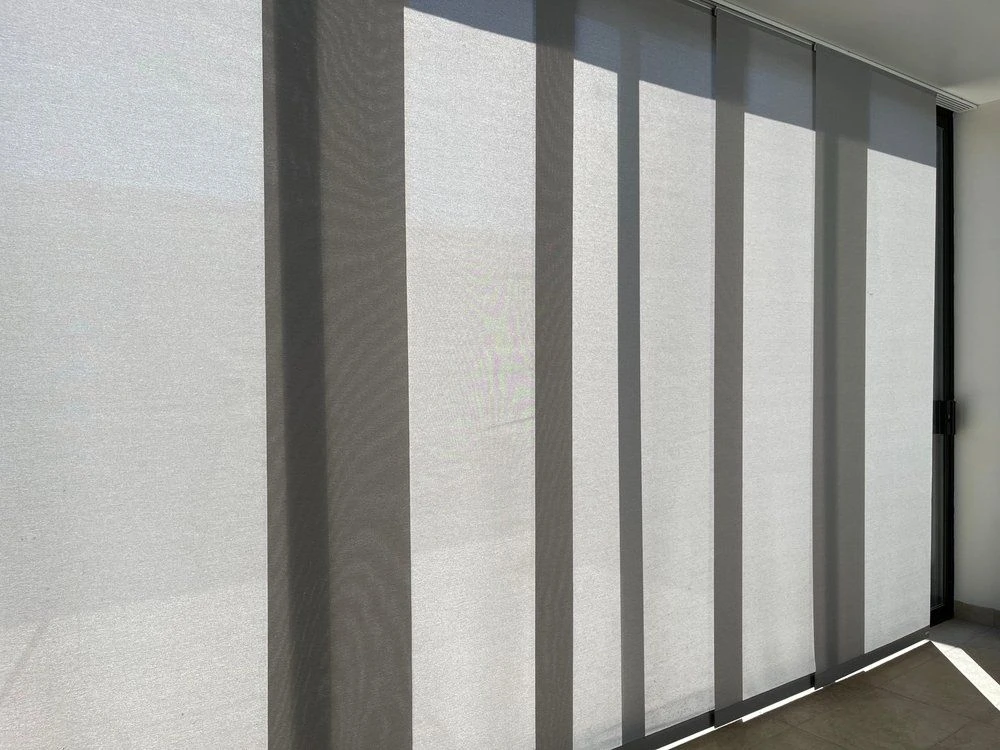 Grey panel glide blinds stacked across a full-height window, timber floor alongside