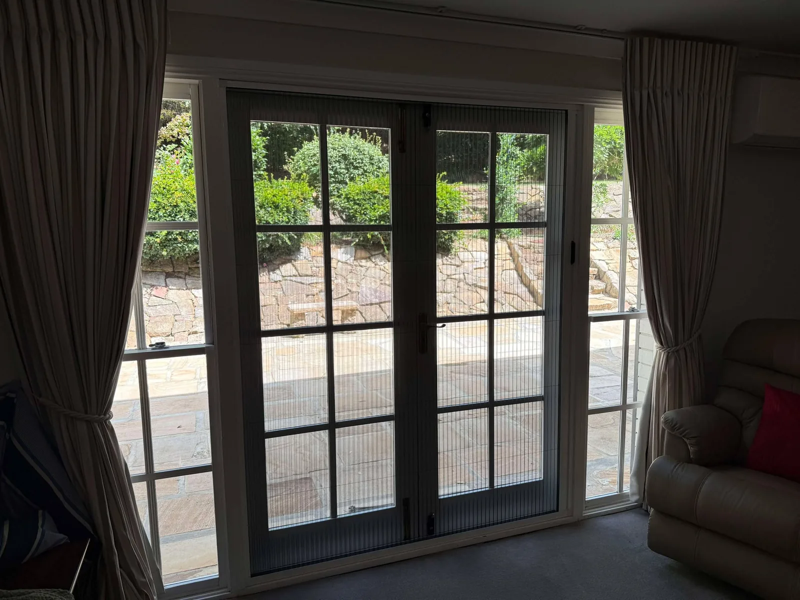 Retractable flyscreen across a wide opening, mesh drawn most of the way